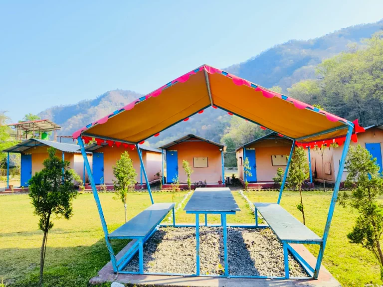 Tent cottages and picnic gazebo with mountain backdrop